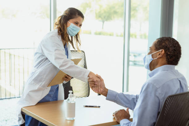 医師は患者と握手をします。両方ともマスクを着用する - patient medical occupation cheerful latin american and hispanic ethnicity ストックフォトと画像