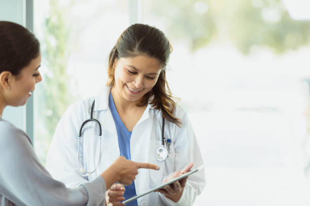 istock Female patient points to digital tablet in doctor's hands 1303713848