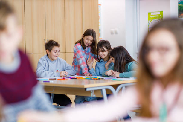 istock Group of happy elementary students writing something in the classroom 1303714094