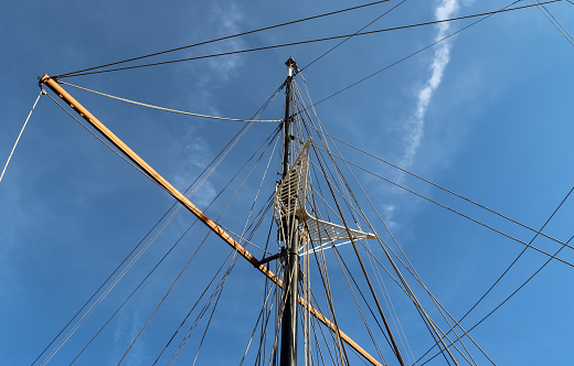 Sailing ship mast against the blue sky on some sailing boats with rigging detailsDetailed close up detail of ropes and cordage in the rigging of an old wooden vintage sailboat.