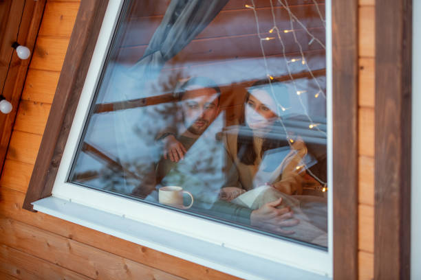istock Young serene affectionate couple in sweaters looking through large window 1303714878