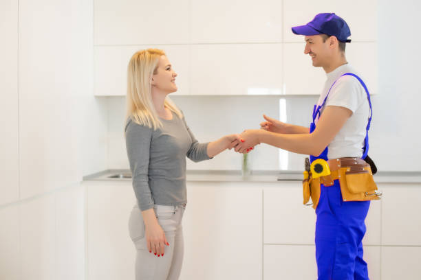 istock Young Woman Looking At Male Technician Checking Dishwasher In Kitchen 1303715168