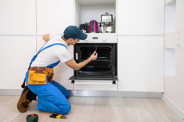 istock young repairman in protective workwear fixing oven in kitchen 1303715267