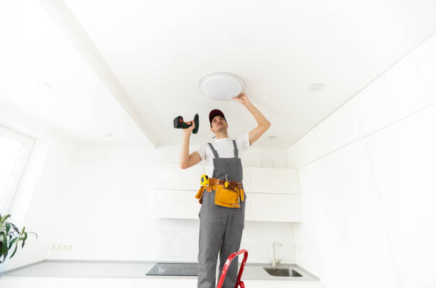 istock Electrician installs a chandelier on the ceiling. Construction concept 1303716421