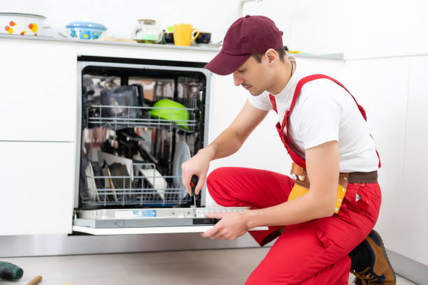 istock Happy master. Male technician sitting near dishwasher with screwdriver in kitchen with instruments and smiling 1303716656
