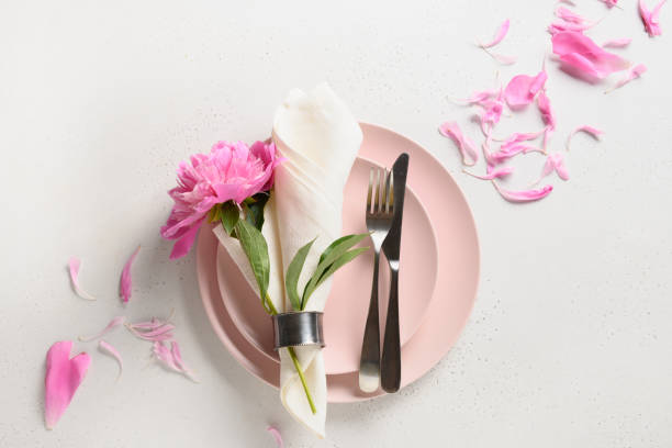 istock Romantic table setting with pink peony flowers on a white table. View from above. 1303716944