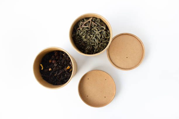 istock Green and black tea in reusable round cardboard packaging isolated on white background. View from above. 1303719447