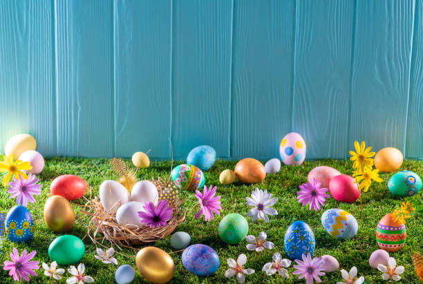 istock Easter eggs nest on turf grass and blue wooden wall with spring flowers 1303722998