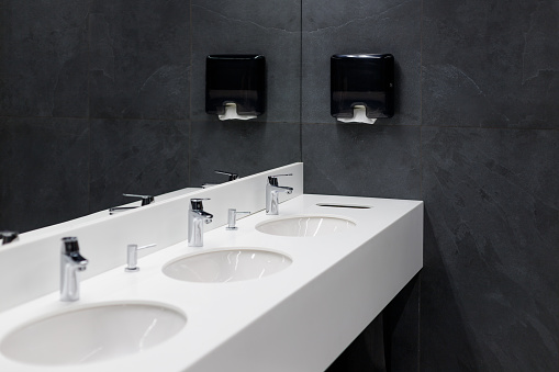 Commercial bathroom, sinks and mirror in public toilet, black modern design