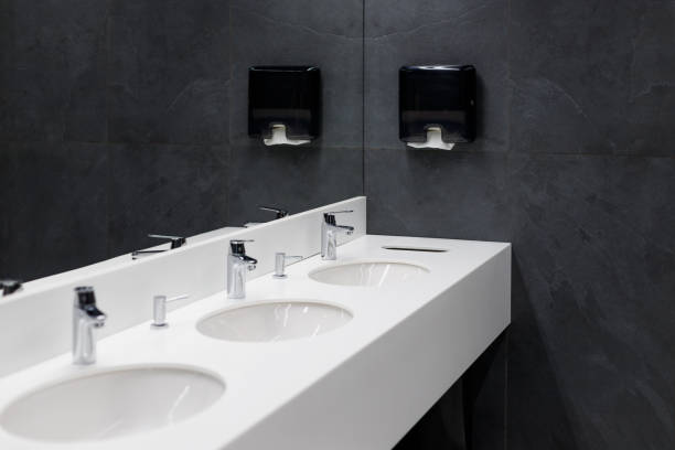 Commercial bathroom, sinks and mirror in public toilet, black modern design Commercial bathroom, sinks and mirror in public toilet, black modern design soap dispenser stock pictures, royalty-free photos & images