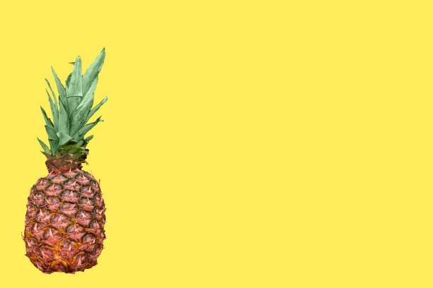 istock ripe pineapple on yellow background 1303725525
