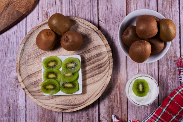 istock Yoghurt glass with kiwis on wooden plate 1303728267