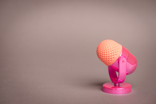 Pink microphone on gray background.