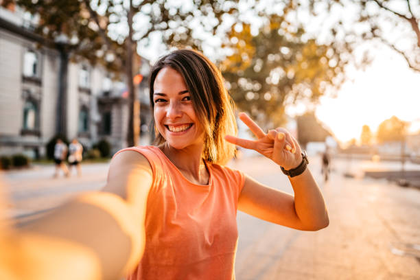 Smiling woman making selfie Beautiful young smiling woman making selfies at sunset. women selfies stock pictures, royalty-free photos & images