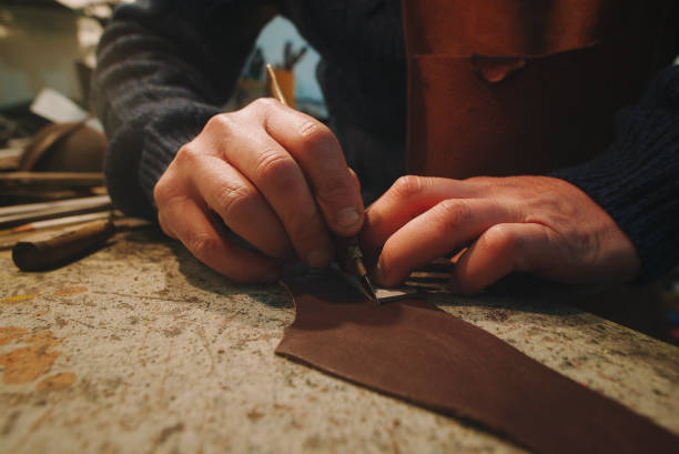 istock hands of craftsman cut leather with utility knife 1303730840