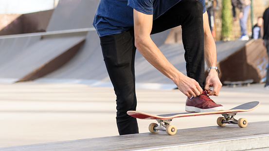 Unrecognizable skateboarder doing olie jump in skatepark