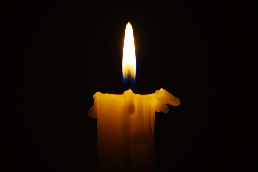 Close-up of burning candle in the dark