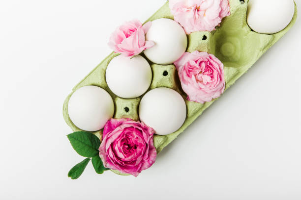 istock Easter composition of eggs and pink flowers. Flat lay on the white background. Easter and Holidays concept. Minimalist style 1303733285