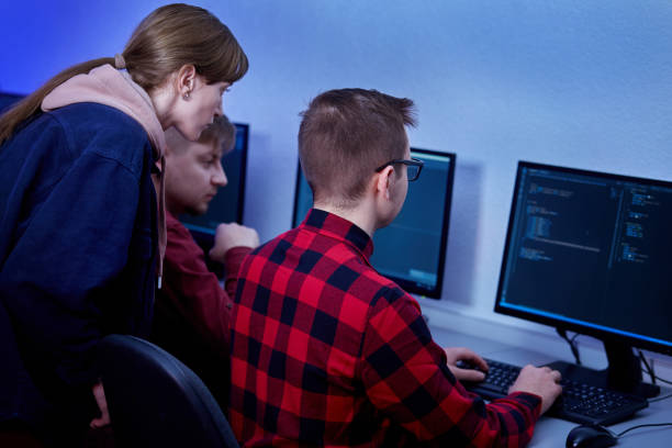 istock Two men and a woman discuss work while sitting in an office. Blue light. 1303735842