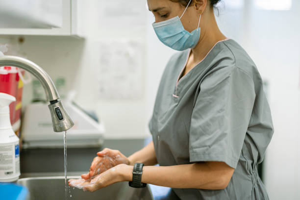 istock Female medical professional washing hands 1303736974