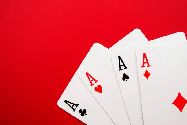 Photo of Four poker cards of aces on red background. Four playing cards of aces.