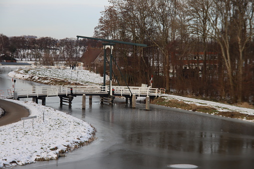 Snow on the meadows with bridge over the ring canal Zuidplaspolder at Moordrecht in the Netherlands with frozen ditches