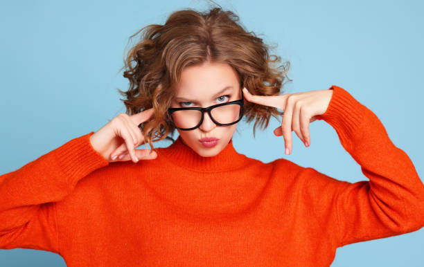 Curious woman in glasses looking at camera