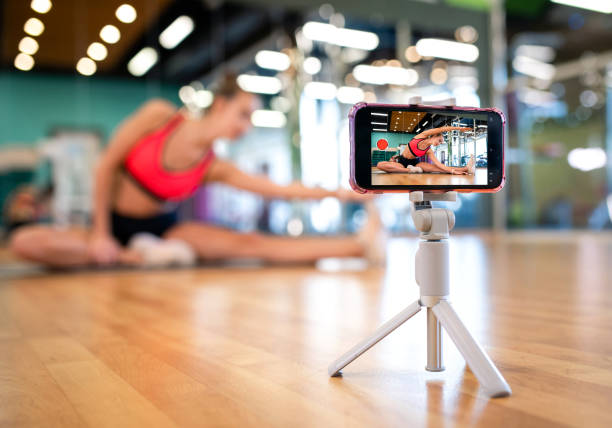 istock Stretching coach performs a fitness workout online via a smartphone 1303744414