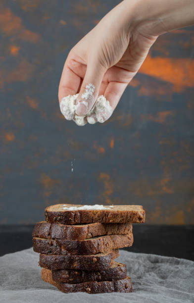 istock Slices of brown bread with flour on a gray tablecloth 1303745358