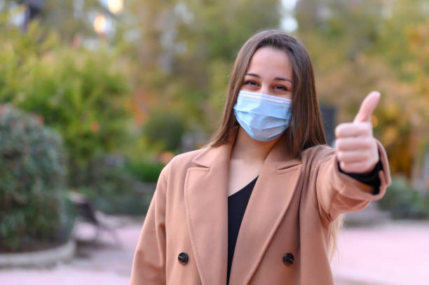 istock woman in mask with thumb up 1303745810