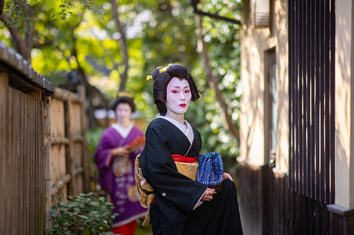 Japanese mid adult female friends visiting Kyoto and experiencing Geiko (Geisha) makeover. Wearing gorgeous kimono for Geisha with 'Oshiroi' special white face makeup.