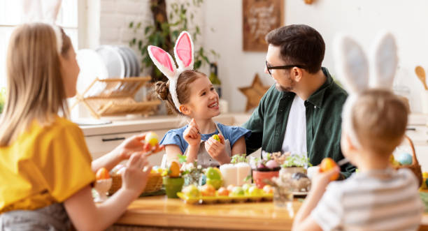 istock Happy family painting Easter eggs in light kitchen 1303747012