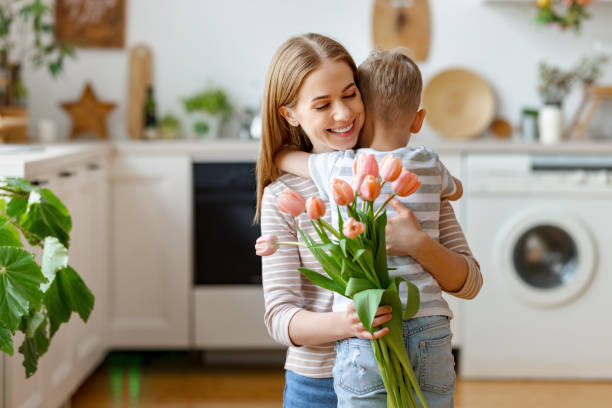 istock Grateful mother with bouquet hugging son 1303747174