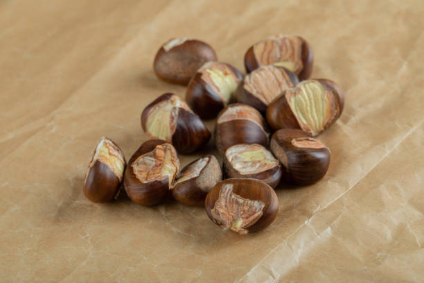 istock Delicious healthy chestnuts on a parchment paper 1303749094