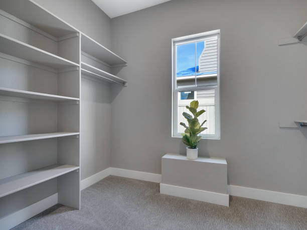 Staged Modern Master Bedroom Walk In Closet with Window Interior Real Estate Listing stock photo