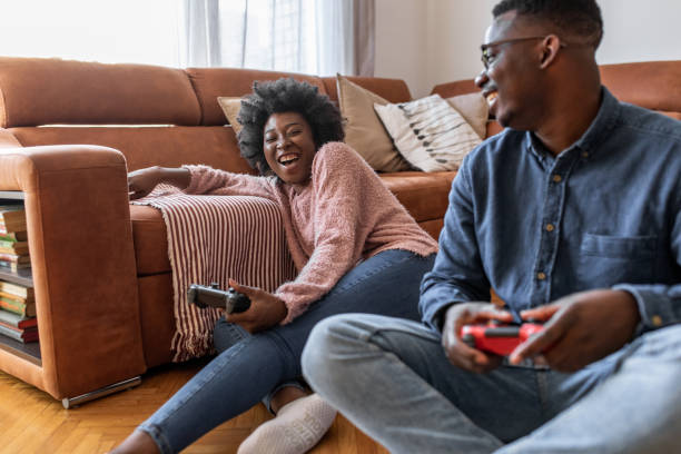 istock Young couple at home having fun and playing video games 1303750191