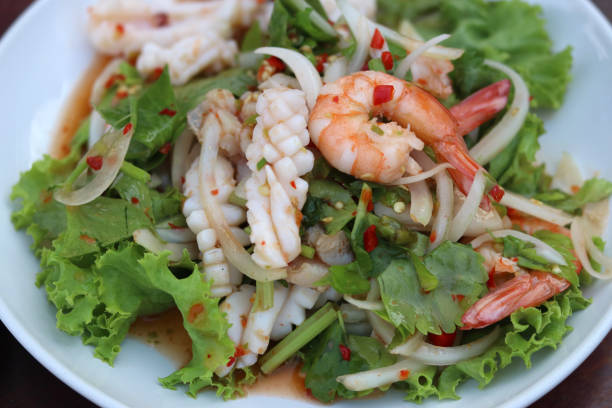 istock Thai Spicy Seafood Salad with shrimp,squid,fish,onion and lettuce. 1303750430