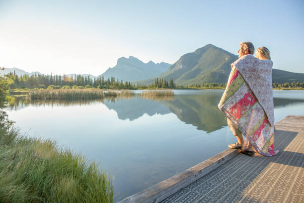 istock Couple relax by mountain lake edge 1303752072