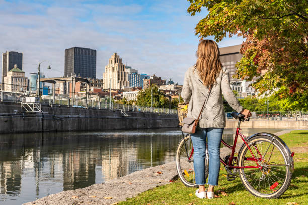 Bike ride in Montreal. Portuguese woman doing a bike ride in Montreal Old Port and looking at the downtown district during a sunrise in the end of summer. montréal photos stock pictures, royalty-free photos & images