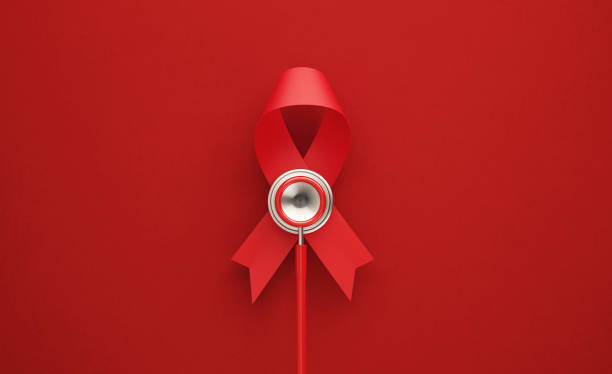 concepto del día mundial del sida - estetoscopio rojo y cinta roja de concienciación sobre el sida sobre fondo rojo - world aids day fotografías e imágenes de stock