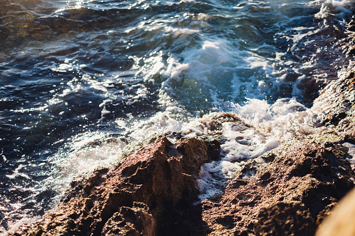 A close-up shot of sea water splashing as it hits the rocks.
