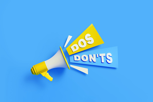 Dos and Don'ts  coming out from a yellow megaphone on blue background. Horizontal composition with copy space. Great use for Dos And Don'ts  concepts.
