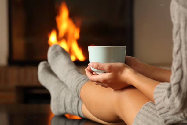 Woman with socks holding coffee in a fireplace