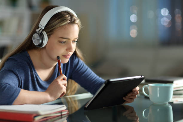 Student e-learning with tablet and headphones Student e-learning with tablet and headphones kindle stock pictures, royalty-free photos & images