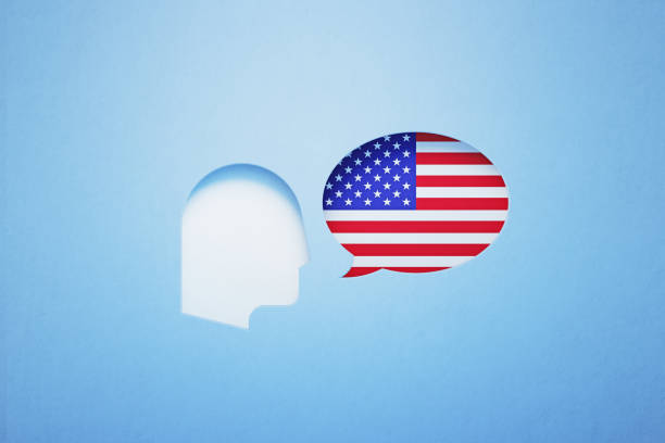 istock American English Learning And Speaking Concept - Speech Bubble Shape Textured With American Flag Sitting Next To A Cut Out Human Head On Blue Background 1303754704