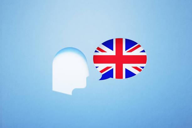 istock British English Learning And Speaking Concept - Speech Bubble Shape Textured With British Flag Sitting Next To A Cut Out Human Head On Blue Background 1303754746