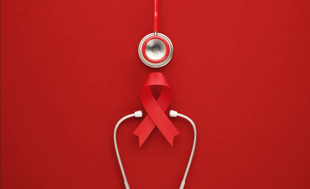 world aids day concept - red stethoscope and red aids awareness ribbon on red background - aids awareness ribbon imagens e fotografias de stock