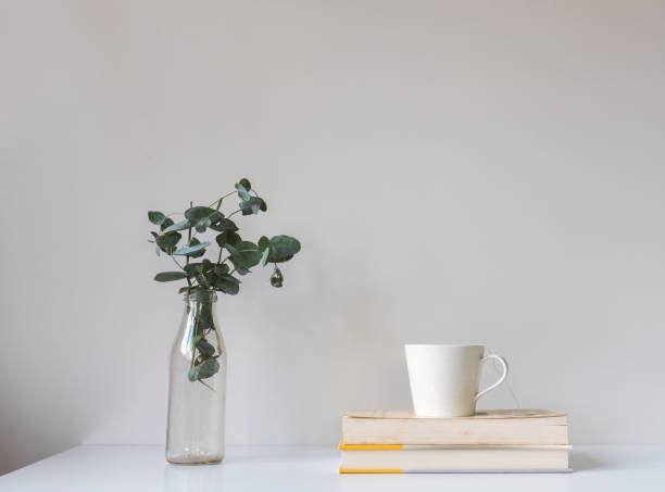 istock White cup on books next to eucalyptus leaves in glass jar 1303755704