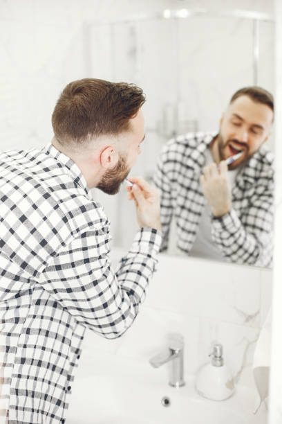 istock Portrait view of a young man brushing his teeth 1303758416