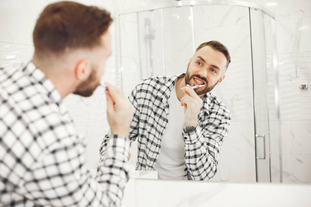 istock Portrait view of a young man brushing his teeth 1303758426